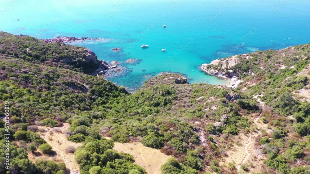 Aerial view of people on the beach in a small paradise bay along the coast, Sardinia island, Italy. Aerial view of people on the beach in a small paradise bay along the coast, Sardinia island, Italy.