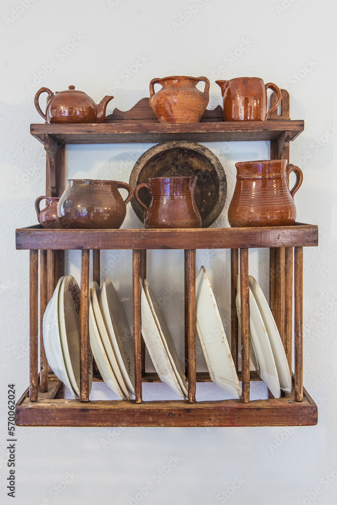 Old wooden plate rack full of pottery Old wooden plate rack full of pottery