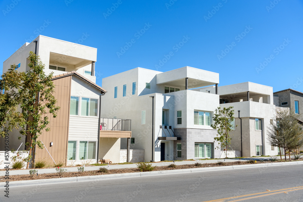 New detached houses along a street in a housing development in California on a sunny autumn day