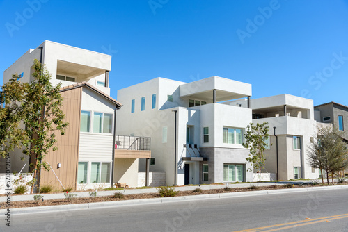 New detached houses along a street in a housing development in California on a sunny autumn day