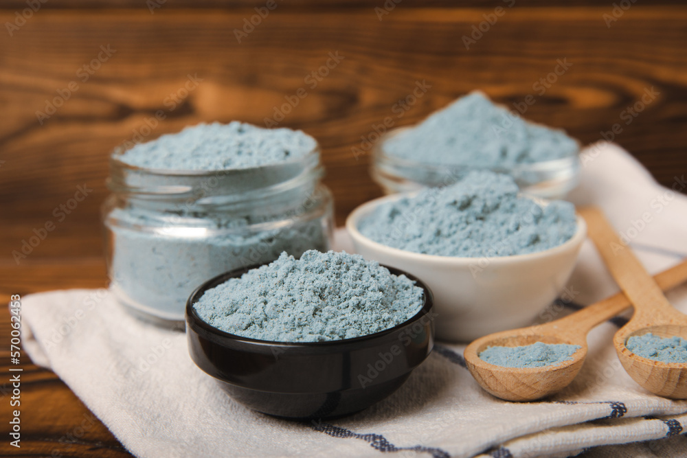 Blue spirulina powder in bowls on a brown table. Natural vegan superfood. Food supplement. Phycocyanin extract. Healthly food. Place for text. Copy space. Blue spirulina powder in bowls on a brown table. Natural vegan superfood. Food supplement. Phycocyanin extract. Healthly food. Place for text. Copy space.