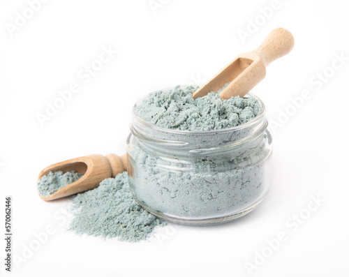 Blue spirulina powder in glass jar and spoon isolated on white background. Natural vegan superfood. Food supplement. Phycocyanin extract. photo