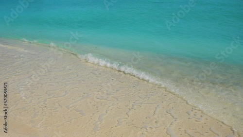 Gentle waves of the turquoise tropical sea on the beach