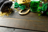 Image of green hat, green clover, horse shoe and copy space on wooden background