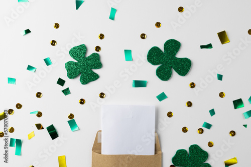 Image of green clover and white paper with copy space on white background