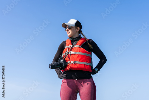 Marine biologist standing on a boat with a digital camera