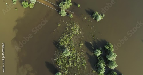 Aerial view of flooded pedestrian bridge and walking path in submerged floodplains of river IJssel during high water period in summer, straight down, Welsumer Waarden, Gelderland, The Netherlands. photo