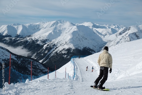 Man on snowboard on Kasprowy Wierch Peak in Tatras Mountains, famous place in Tatras with cable railway. Poland. Tatra National Park