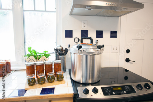 Home Canning jalapenos in jars and a batch of chili with a pressure cooker. Food preservation is key to gardening and homesteading. Pressure canning makes food shelf stable. 