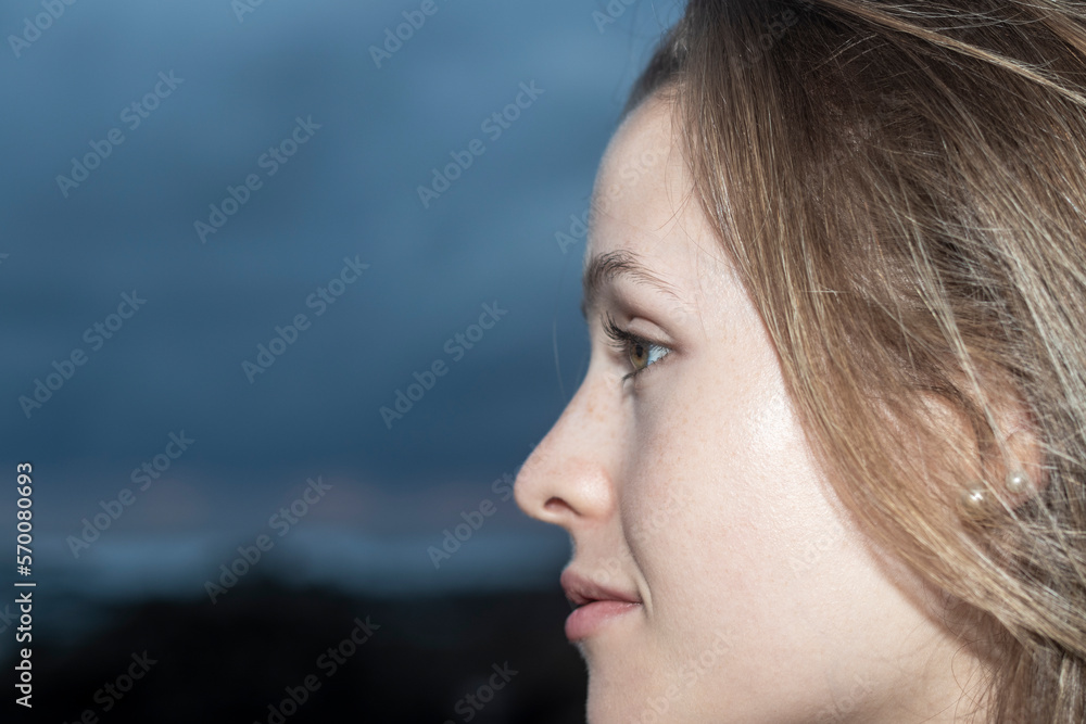 portrait of blonde woman in profile on the beach at sunset portrait of blonde woman in profile on the beach at sunset