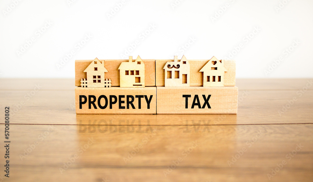 Property tax symbol. Concept words Property tax on wooden blocks. Beautiful wooden table white background. House models on wooden blocks. Business and property tax concept. Copy space. Property tax symbol. Concept words Property tax on wooden blocks. Beautiful wooden table white background. House models on wooden blocks. Business and property tax concept. Copy space.