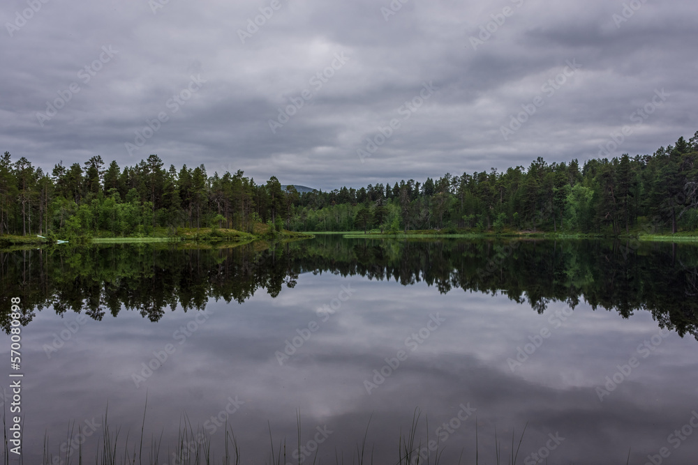 Fototapeta premium Peaceful landscape of Lake Inari with the midnight sun in Lapland, Finland