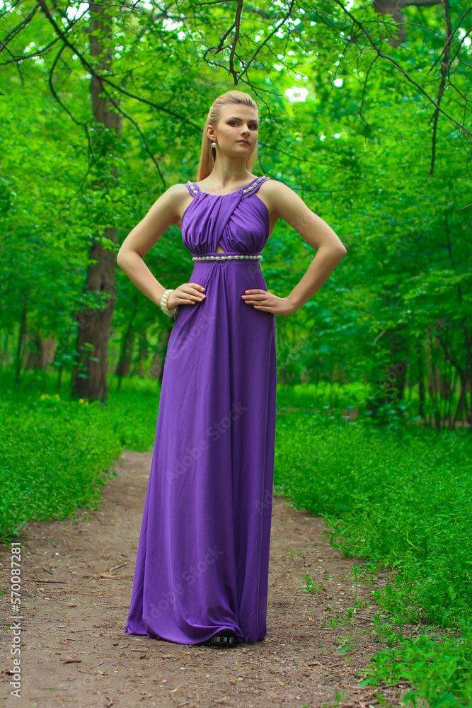 blonde beautiful natural girl with blonde hair in a lilac dress in nature, in the park, in the garden by a tree, with makeup and hairstyle without a bra blonde beautiful natural girl with blonde hair in a lilac dress in nature, in the park, in the garden by a tree, with makeup and hairstyle without a bra