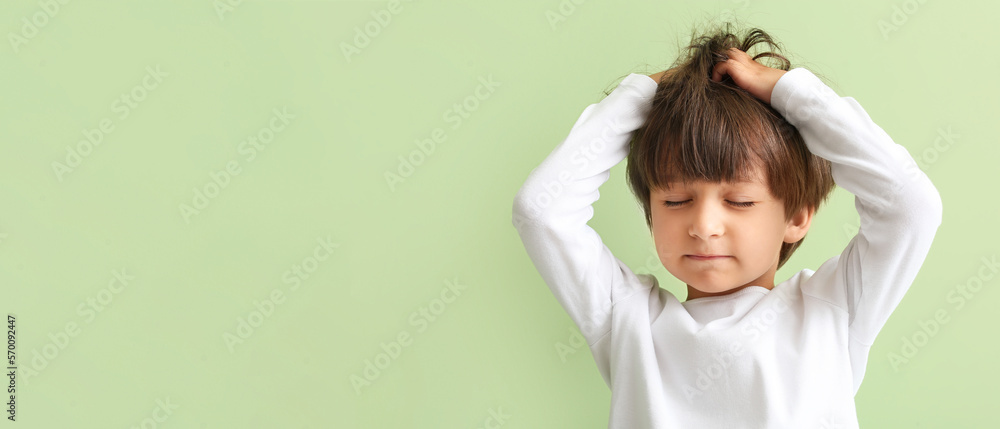Little boy suffering from head ache on green background with space for text - obrazy, fototapety, plakaty 