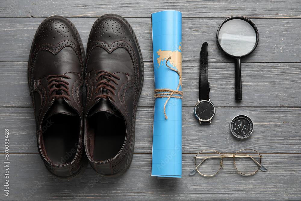 Naklejka premium Compass with traveler accessories on grey wooden background
