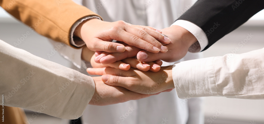 Fototapeta premium Business partners. Group of people holding hands together in office, closeup. Banner design
