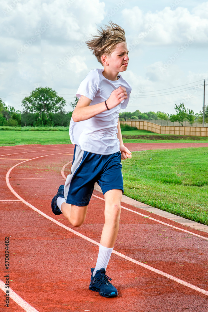 Male youth track runner racing at top speed