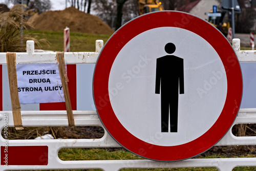 Plac budowy . Barierki i znak drogowy : " zakaz ruchu pieszych" .