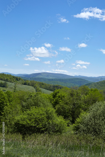 Landscape photograph with green rolling hills and blue sky. Summer scene.