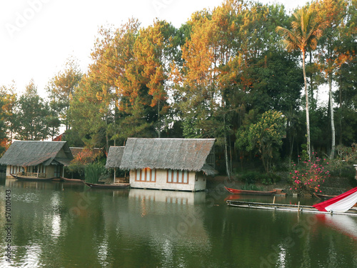Small house in village with lake and lush trees