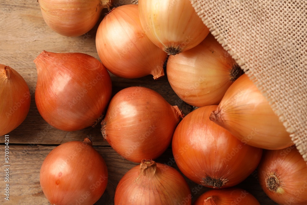 Many ripe onions on wooden table, flat lay Many ripe onions on wooden table, flat lay