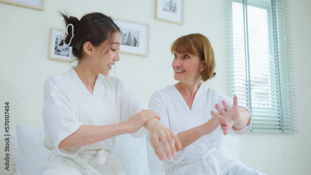 Asian young woman put smooth and soft skin care with Caucasian mother. Asian young woman put smooth and soft skin care with Caucasian mother.