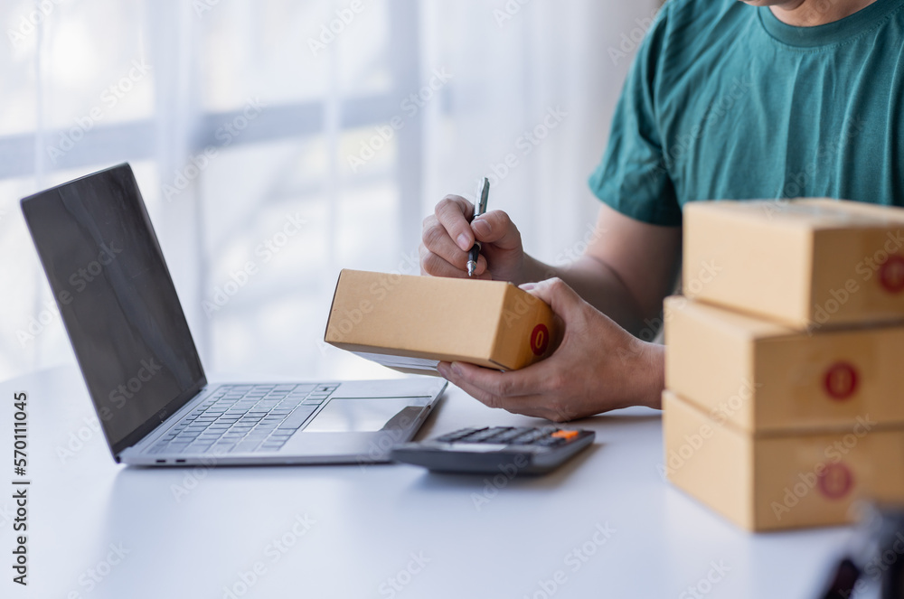 Close up of Hand man small business SME entrepreneur working at home, online marketing, packing boxes, SME sellers, concept, e-commerce team, online sales. Close up of Hand man small business SME entrepreneur working at home, online marketing, packing boxes, SME sellers, concept, e-commerce team, online sales.