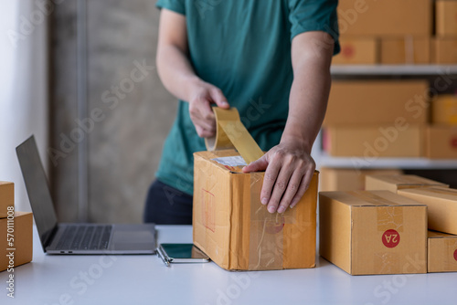 Close up of Hand man small business SME entrepreneur working at home, online marketing, packing boxes, SME sellers, concept, e-commerce team, online sales. © David