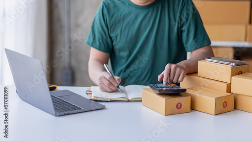 Close up of Hand man small business SME entrepreneur working at home, online marketing, packing boxes, SME sellers, concept, e-commerce team, online sales.