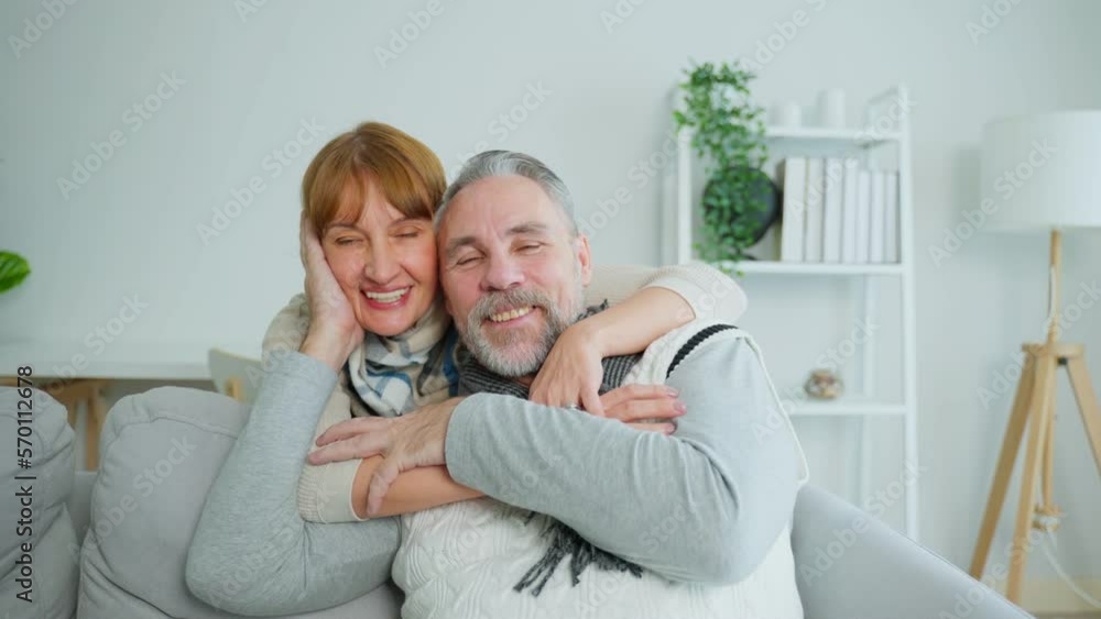 Portrait of Caucasian senior elderly couple sit on sofa in living room. Portrait of Caucasian senior elderly couple sit on sofa in living room.