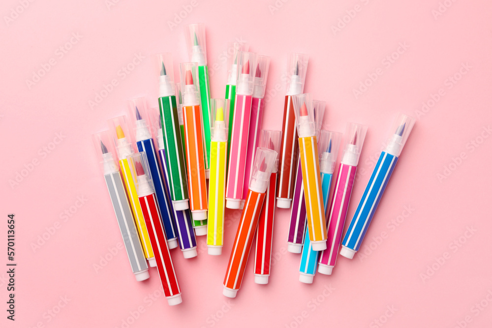 Many bright markers on pink background, flat lay Many bright markers on pink background, flat lay