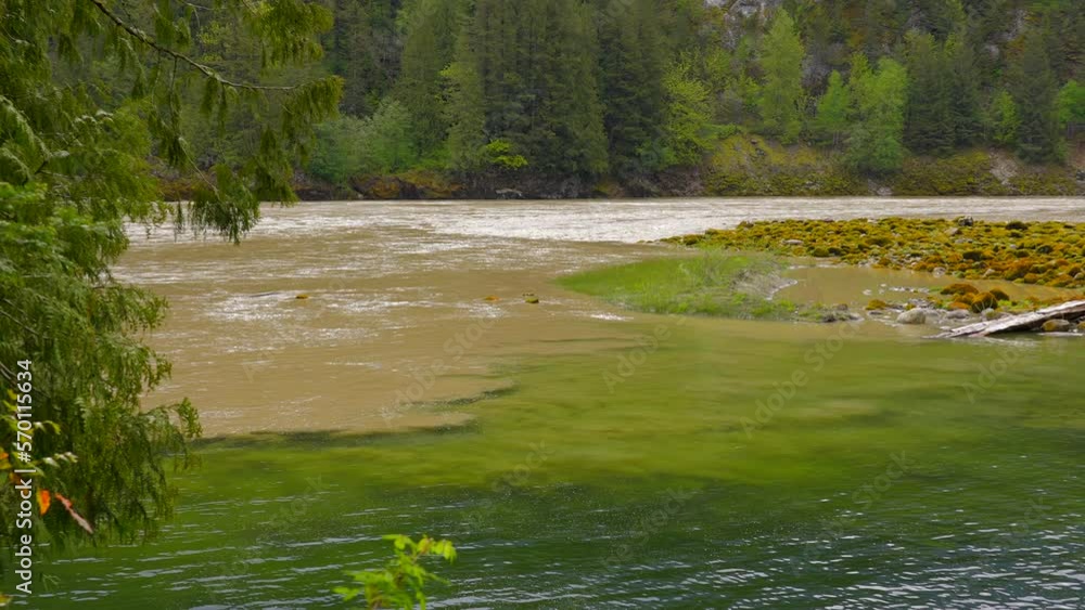 Establishing shot of majestic mountain river with mountain background in Vancouver, Canada, North America. Day time on April 2022. Still camera view. ProRes 422 HQ. Establishing shot of majestic mountain river with mountain background in Vancouver, Canada, North America. Day time on April 2022. Still camera view. ProRes 422 HQ.