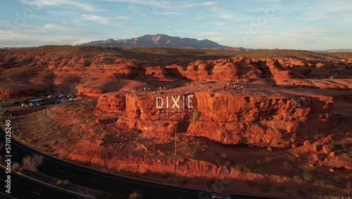 Aerial View of Dixie Rock, St. George Utah USA, People on Tourist Attraction and Traffic on Red Hills Parkway at Sunset, Revealing Drone Shot photo