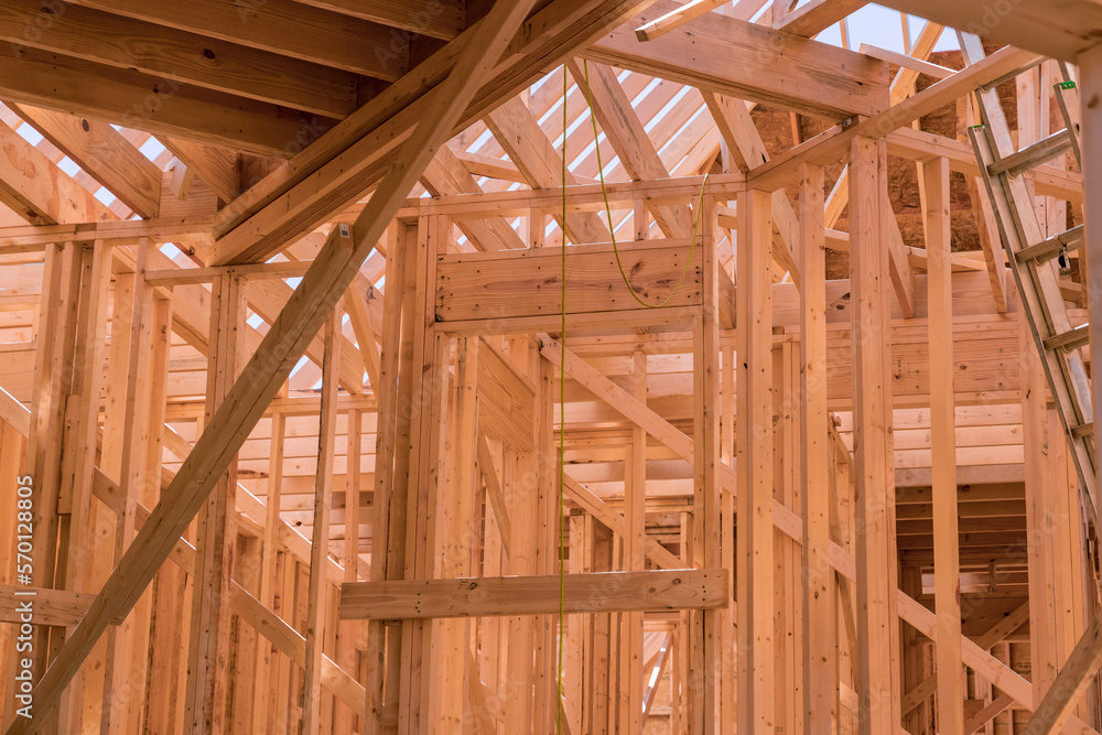 As part construction newly constructed stick house wooden roof rafter timber beams which will be supported by truss frames As part construction newly constructed stick house wooden roof rafter timber beams which will be supported by truss frames