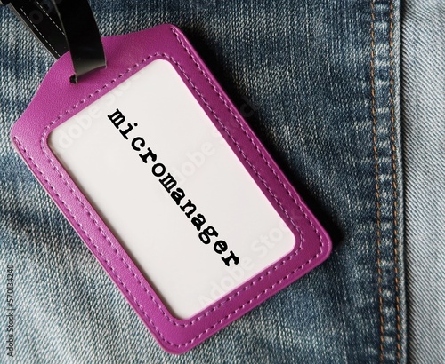 Purple ID card holder with text written MICROMANAGER refer to a boss or manager who gives excessive supervision to employees, control every part of project photo