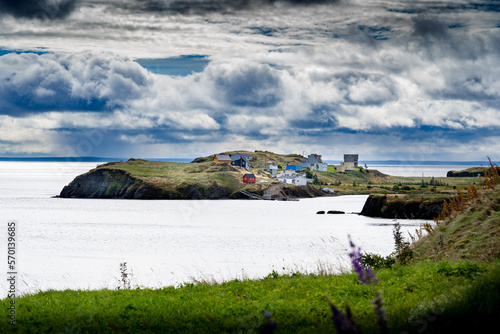 Scenic landscape of small east coast homes on a peninsula overlooking high cliffs along the Atlantic Ocean near Port Rexton Newfoundland. photo