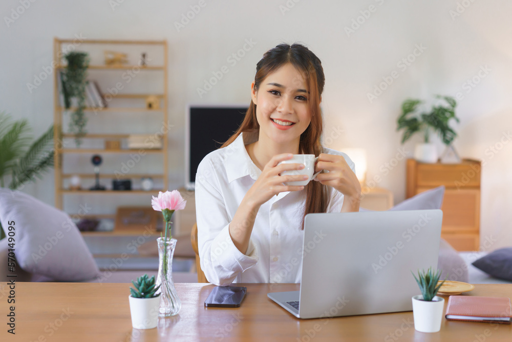 Relaxing time concept, Women is drinking coffee and working on laptop at modern home office Relaxing time concept, Women is drinking coffee and working on laptop at modern home office