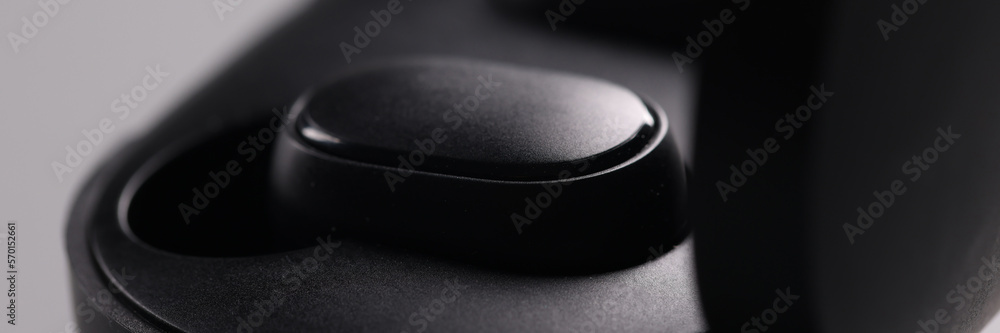 Black electronic bluetooth headphones and technical cases on grey background Black electronic bluetooth headphones and technical cases on grey background