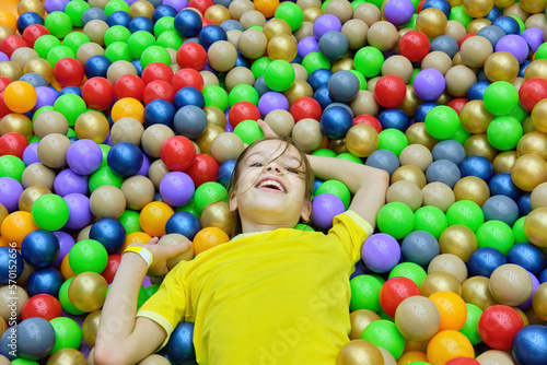The girl child is having fun playing with colored balls