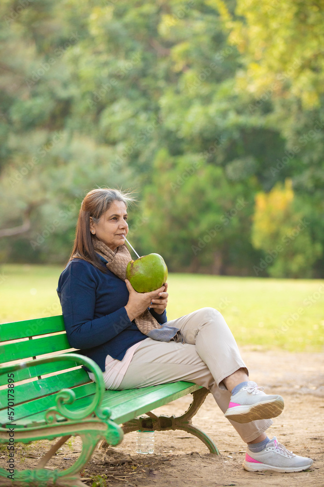 Indian senior woman drinking coconut water at park Indian senior woman drinking coconut water at park