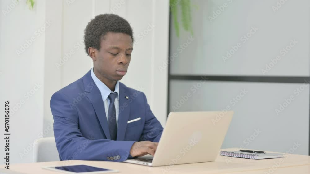 African Businessman Typing on Laptop in Office African Businessman Typing on Laptop in Office