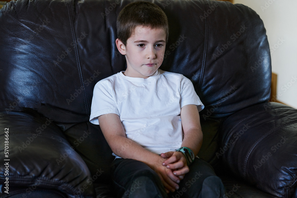 child sitting on a dark couch watching TV child sitting on a dark couch watching TV