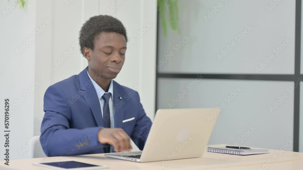 Thumbs Down by African Businessman Working on Laptop Thumbs Down by African Businessman Working on Laptop