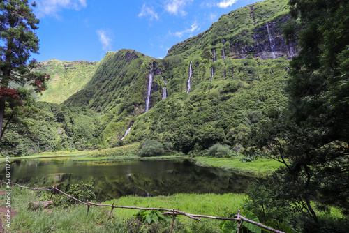 View of the idyllic Poço da Alagoinha lagoon at Flores island in AzoresSeveral waterfalls that spring from the mountain and feed the lagoon in which they are reflected
