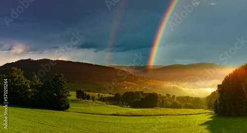 Regenbogen über einer Hügellandschaft