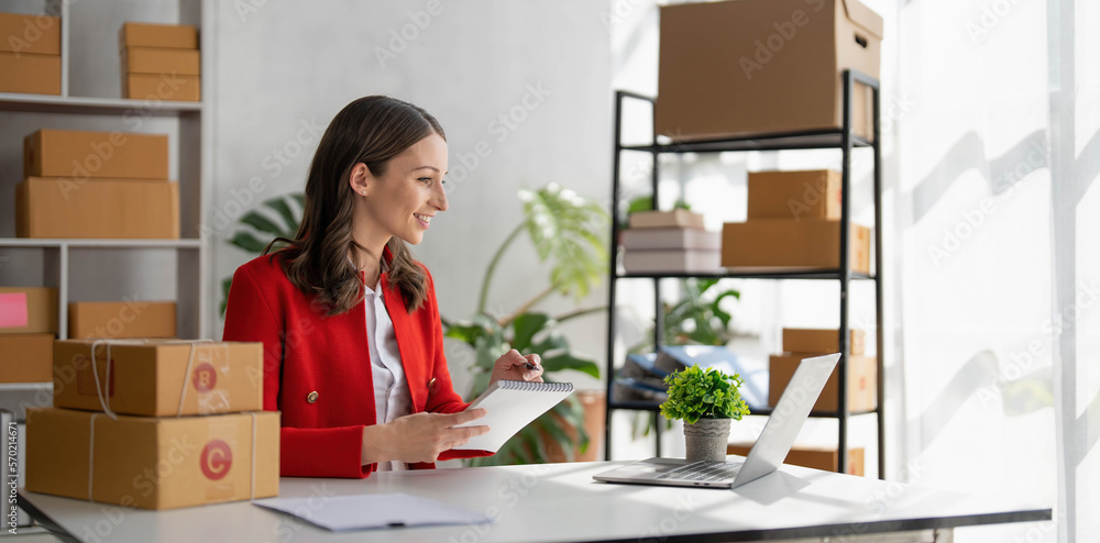 Portrait business woman smile and use tablet checking information on parcel shipping box before send to customer. Entrepreneur small business working at home. SME business online marketing. Portrait business woman smile and use tablet checking information on parcel shipping box before send to customer. Entrepreneur small business working at home. SME business online marketing.