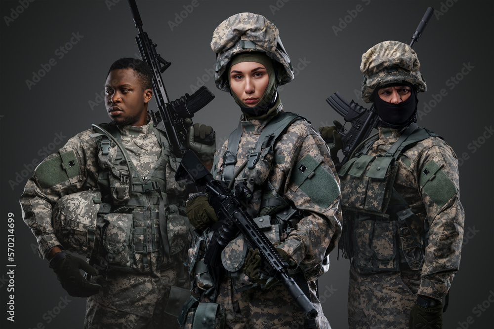 Portrait of three soldiers dressed in camouflage uniform holding rifles. Portrait of three soldiers dressed in camouflage uniform holding rifles.