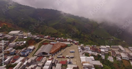 Drone shot over Ecuadorian town edge with mountains in the distance