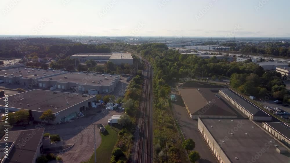 Push in drone view on train tracks in an industrial area. Big city in the background at golden hour. Push in drone view on train tracks in an industrial area. Big city in the background at golden hour.
