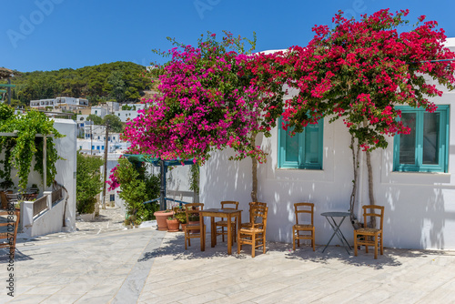 Traditional Cycladitic alley with a narrow street, whitewashed houses and a blooming bougainvillea in lefkes village, Paros island, Greece. © valantis minogiannis